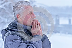 Portrait of thoughtful senior man at winter park