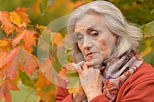 Portrait of thoughtful senior woman in autumn park