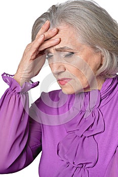 Portrait of thoughtful senior woman with headache on white background