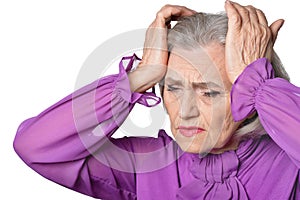 Portrait of thoughtful senior woman with headache on white background