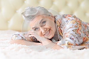 Portrait of thoughtful senior woman lying on bed