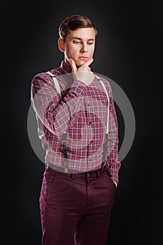 Portrait of thoughtful serious clever scientific man in vintage shirt bow tie with hairstyle keeping hand under chin while stand