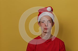 Portrait of a thoughtful teenage boy in the studio on a yellow paper background