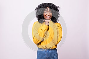 Portrait of thoughtful young african woman with curly black hair looking up with her hand on the chin. Concept of decision making