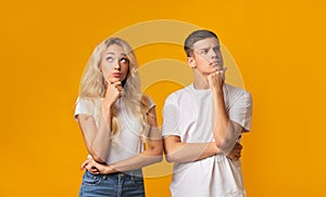 Portrait of thoughtful young couple on yellow background