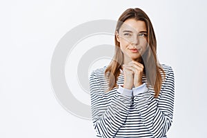 Portrait of thoughtful young woman with blond hair, squinting pensive, having interesting idea, looking left at copy