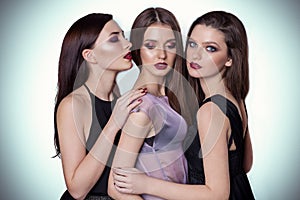 Portrait of three beautiful young women friends in the studio on a white background with yarkis makeup are close to each other