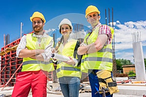 Portrait of three confident and reliable young employees at construction site