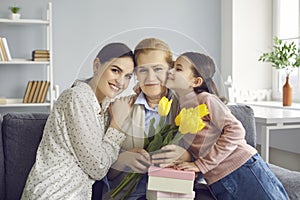 Portrait of three generations of women, mother, grandmother and granddaughter celebrating the event.