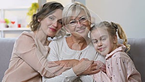 Portrait of three generations of women smiling at camera, happy family together