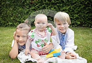 portrait of three happy ukrainian children of different ages in national clothes. education of patriotism