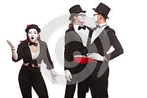 Portrait of three mime artists performing, isolated on white background. Mimes stand thinking. Symbol of finding