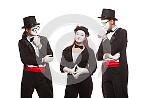 Portrait of three mime artists performing, isolated on white background. Mimes stand thinking. Symbol of finding