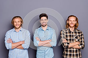 Portrait of three nice attractive content cheerful cheery guys folded arms wearing checked shirt isolated over gray