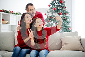 Portrait of three nice attractive lovely positive cheerful cheery glad excited family sitting on divan taking making