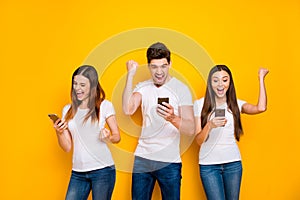 Portrait of three nice-looking attractive lovely cheerful cheery ecstatic overjoyed person using wi-fi connection 5g app