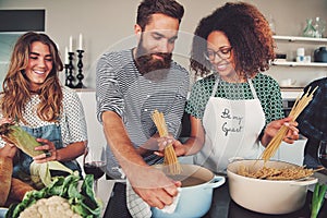 Three friends cooking spaghetti