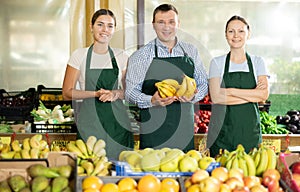 Portrait of three salespeople in the fruit and vegetable department of supermarket photo