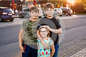 Portrait of three siblings children. Two kids brothers boys and little cute preschool sister girl having fun together