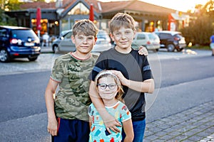 Portrait of three siblings children. Two kids brothers boys and little cute preschool sister girl having fun together