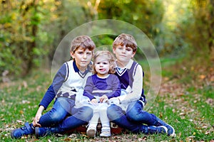 Portrait of three siblings children. Two kids brothers boys and little cute toddler sister girl having fun together in