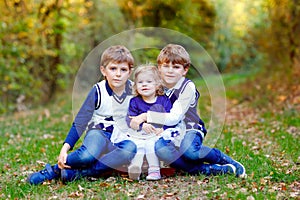 Portrait of three siblings children. Two kids brothers boys and little cute toddler sister girl having fun together in
