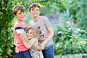 Portrait of three siblings children. Two kids brothers boys and little cute toddler sister girl having fun together in