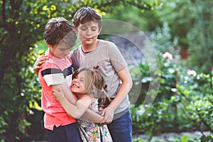 Portrait of three siblings children. Two kids brothers boys and little cute toddler sister girl having fun together in