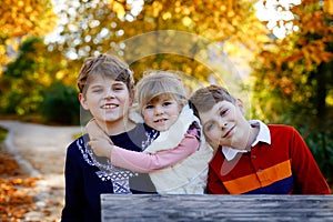 Portrait of three siblings children. Two kids brothers boys and little cute toddler sister girl having fun together in