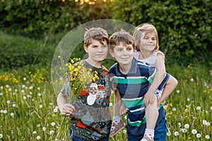 Portrait of three siblings children. Two kids brothers boys and little cute toddler sister girl having fun together on