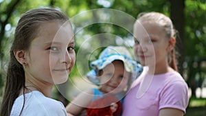 Portrait of three smiling girls posing in a park in the summer