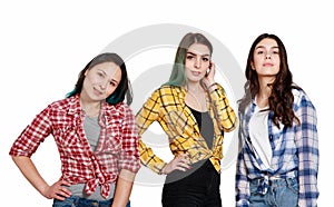Portrait of three young beautiful slender girls women in plaid shirts red, yellow and blue. isolated on white