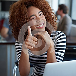 Portrait, thumbs up and black woman with laptop in office, workspace or working in creative career. Female person