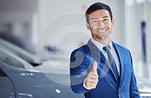 Portrait, thumbs up and car salesman smile at showroom for ok, yes and welcome. Face, like hand gesture and dealership