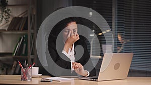 Portrait of tired African American woman suffers from overwork and headache. Businesswoman posing at workplace, sitting