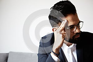 Portrait of tired handsome bearded man taking rest at home. Young handsome man wearing glasses thinking with close eyes