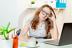 Portrait of a tired office worker at a computer