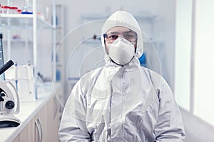Portrait of tired scientist wearing coverall with protection glasses photo
