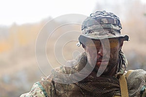 Portrait of a tired soldier with a dirty face. He looking at camera.