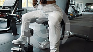 Portrait of tired woman in sportswear with sports bottle in gym