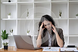 Portrait of tired young business Asian woman work with documents tax laptop computer in office. Sad, unhappy, Worried