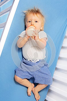 Portrait of toddler boy with formula in the bed