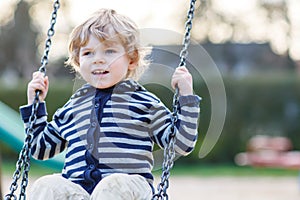 Portrait of toddler boy having fun on outdoor playground