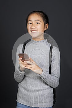 Portrait toothy smiling face of asian teenager with smart phone in hand