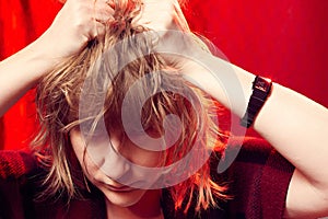 Portrait of tousled disheveled middle-aged woman looking like a madwoman on red background in studio. Actress during the