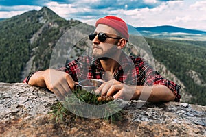 Portrait of a traveler with a mountain background. Vacations and tourism concept.