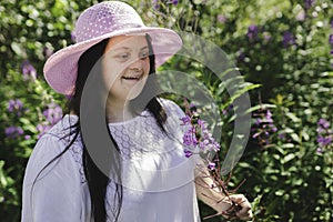 Portrait of trisomy adult outside having fun with flowers