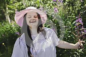 Portrait of trisomy adult outside having fun with flowers