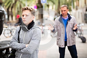 Troubled teen boy with man stranger scolding him