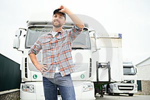 Portrait of trucker standing by his truck ready for driving. Driver occupation. Transportation services